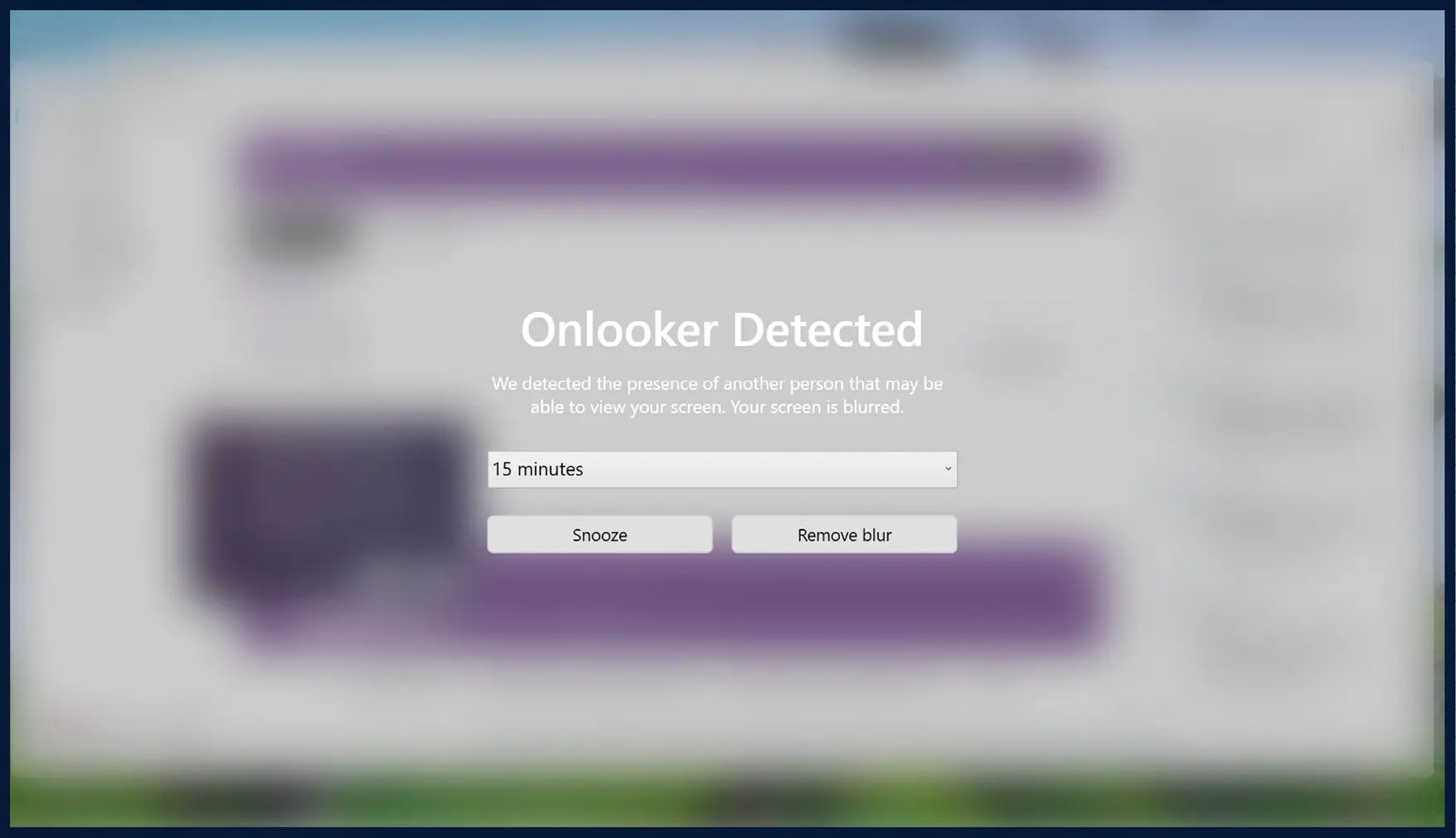 A screenshot of the onlooker detection feature. The background of the screen is blurred, and the text on screen reads, “Onlooker Detected. We detected the presence of another person that may be able to view your screen. Your screen is blurred.” A dropdown menu has “15 minutes” selected, with a “Snooze” button and “Remove blur” button underneath. 