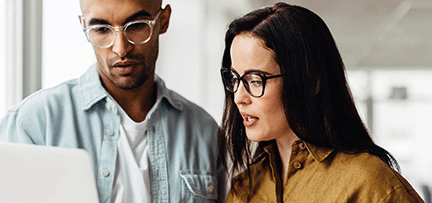 Two people looking at a PC 