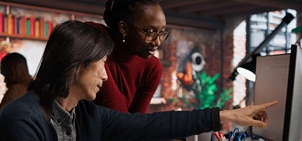 Two people looking at a computer screen in a modern office 